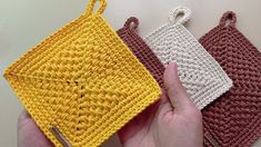 three crocheted purses are shown in different colors and sizes, one is yellow, the other is brown