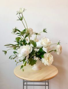 a vase with white flowers is sitting on a table