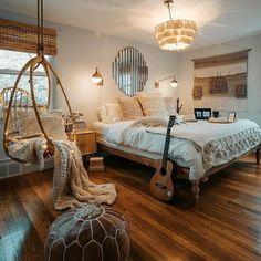 a bed room with a neatly made bed and a guitar hanging on the wall next to it