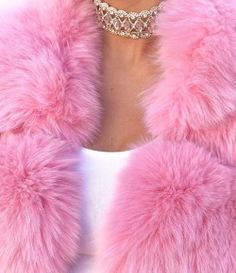 a close up of a woman wearing a pink fur coat