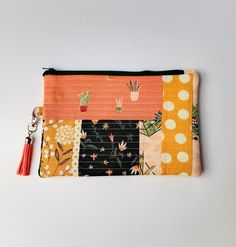 an orange and black patchwork purse with a tassel