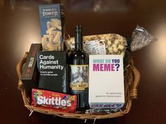 a basket filled with wine, snacks and greeting cards for someone's birthday or other special occasion