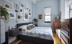 a bed room with a neatly made bed and pictures on the wall