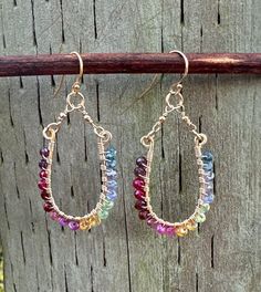 Gorgeous open oval hoop earrings, gold filled components and ear wires, flawless gemstones meticulously wrapped in gold around the frames. 2 inches in length, these statement earrings do not go unnoticed! Sparkling gold and an stay of gorgeous colors on unique frames. Perfect gift accessory!  Gemstones include: Tourmaline Spinel Garnet Sapphire Citrine Kyanite Tanzanite Amethyst  Topaz Iolite Elegant Multicolor Handmade Hoop Earrings, Elegant Multi-stone Hoop Jewelry, Multicolor Multi-stone Hoop Earrings As Gift, Elegant Multicolor Multi-stone Earrings, Multicolor Multi-stone Hoop Earrings, Beaded Jewelry Designs, Gold Filled Earrings, Wire Earrings, Gift Accessories