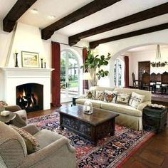 a living room filled with furniture and a fire place in the middle of an open floor plan