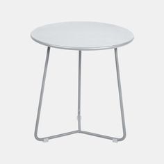 a white side table with metal legs and a round top, on a white background