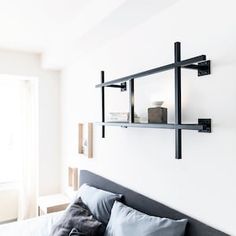 a bed with pillows and two shelves on the wall