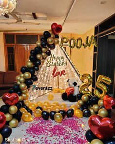 a birthday party with balloons and streamers in the shape of a teepee tent