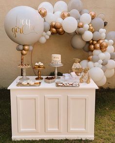 a dessert table with balloons and cake on it