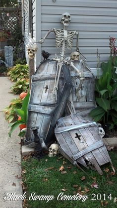 a skeleton sitting on top of a wooden barrel next to a planter filled with flowers