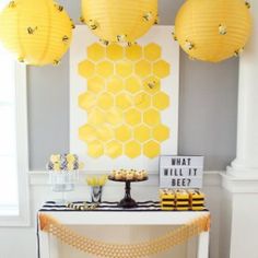 the dessert table is decorated with honeycombs and yellow paper lantern lights hanging from the ceiling