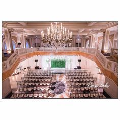 an empty ballroom with chandelier and chairs set up for a formal function or wedding