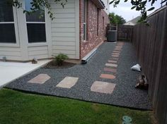 a back yard with gravel and stepping stones