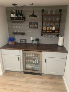 a kitchen with white cabinets and shelves filled with bottles