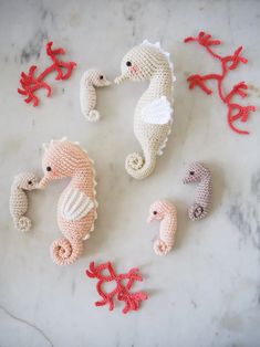 crocheted seahorses and baby sea horses on a marble surface with corals