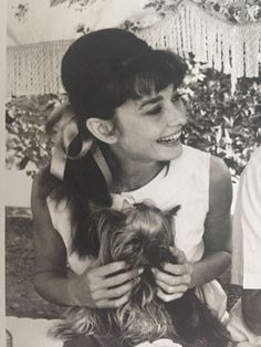 an old black and white photo of a young boy holding a dog in his lap