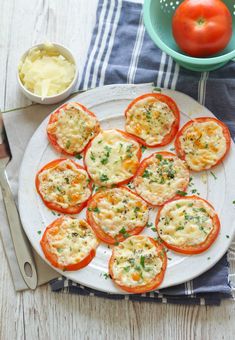 tomatoes with cheese and herbs on a white plate