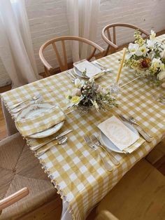 the table is set with plates, silverware and flowers