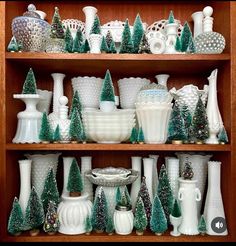 a shelf filled with lots of white and green christmas decorations