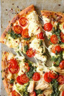 a pizza with tomatoes, broccoli and cheese on it is cut into slices