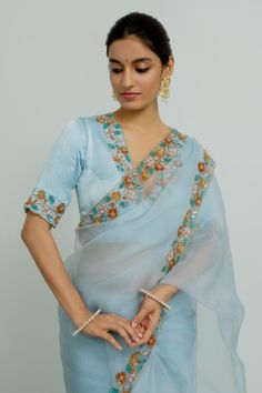 Powder blue silk organza saree with floral and sequins hand embroidered borders. Comes with a blouse.
Components: 2
Pattern: Hand embroidered
Type Of Work: Floral, Sequins
Neckline: Deep V Neck
Sleeve Type: Half
Fabric: Silk organza
Color: Blue
Other Details: 
Disclaimer : The product will dispose off some color, since it is hand dyed.
Occasion: Wedding - Aza Fashions Transitional Embroidered Organza Pre-draped Saree, Blue Embroidered Pre-draped Saree For Transitional Season, Embroidered Organza Blouse For Diwali, Diwali Embroidered Organza Blouse, Party Pre-draped Chanderi Saree With Floral Embroidery, Festive Bollywood Organza Blouse, Embroidered Organza Blouse With Traditional Drape, Festive Unstitched Organza Blouse Piece, Traditional Drape Embroidered Organza Blouse