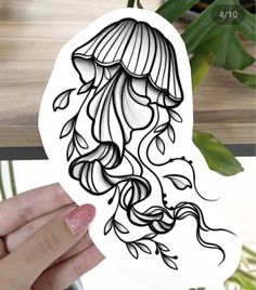 a hand holding up a sticker with an image of a jellyfish