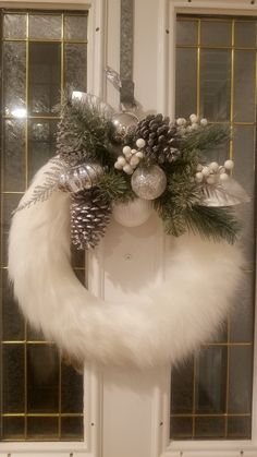 a christmas wreath with pine cones and silver ornaments