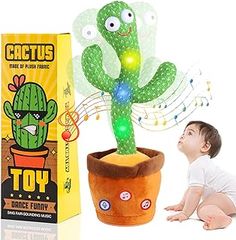 a baby sitting next to a toy cactus in a pot with musical notes on it