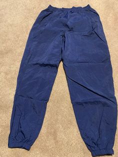 These vintage Nike track pants joggers are in excellent condition. They are a size XL and have a drawstring waist and zip up around the ankles with elastic at the ankles as well . Smoke free home.  Zippered back pockets and 2 side pockets.  Wrinkly material and not soft sweatpant material.  Rise about 14"  Inseam about  33"  Waist about 15" with an elastic waistband as well as drawstring. Nike Navy Bottoms For Streetwear, Vintage Nike Track Pants, Windbreaker Track Pants, Blue Windbreaker, Nike Track Pants, Mens Vintage, Nike Blue, Jogger Sweatpants, Vintage Nike