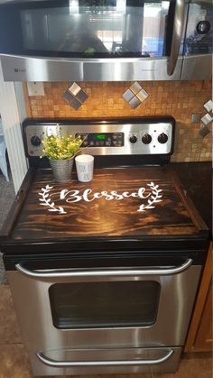 a stove top oven sitting inside of a kitchen next to a microwave and potted plant