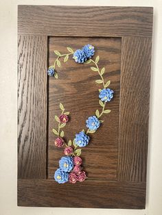 a wooden frame with flowers and leaves on it