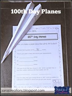 a paper airplane sitting on top of a table next to a piece of paper with the words 100th day planes