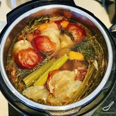 a pot filled with vegetables sitting on top of a stove