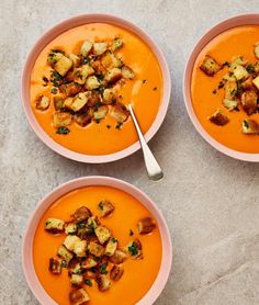 three bowls of soup with croutons and bread