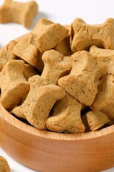 a wooden bowl filled with dog treats on top of a table