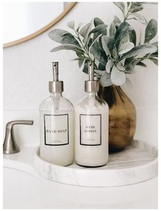 two soap dispensers sitting on top of a bathroom counter next to a mirror