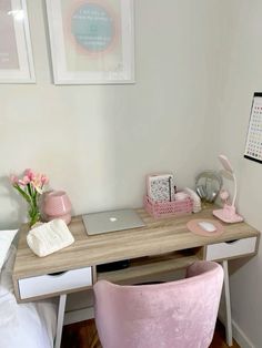 a desk with a laptop on it and pink chair next to it in a bedroom