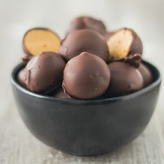 a black bowl filled with chocolates on top of a table