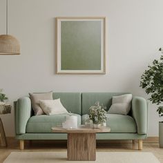 a living room with a couch, table and potted plants on the floor in front of it