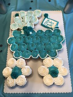 a birthday cake with blue and white frosting flowers on the top is shaped like a train