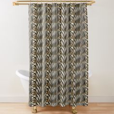 a zebra print shower curtain hanging on a bathtub next to a white tub and wooden floor