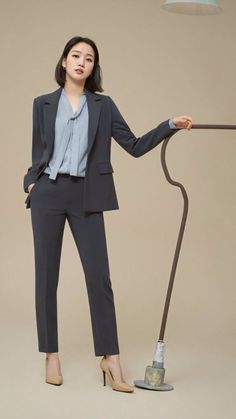 a woman standing in front of a lamp with her hands on the pole and looking up