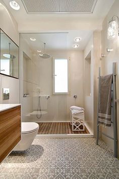 a bathroom with a toilet, sink and shower in it's center area is shown