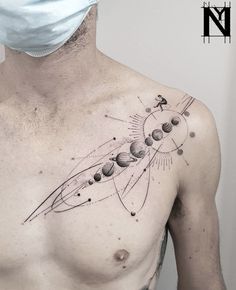 a man wearing a surgical mask and showing his chest with an image of the solar system on it