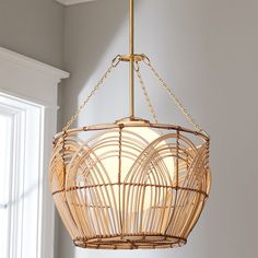 a light fixture hanging from the ceiling in a room with white walls and window frames