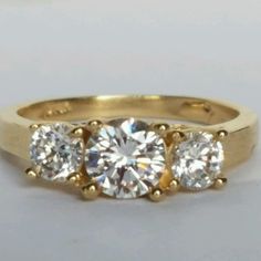 three stone diamond ring in yellow gold with diamonds on the sides and four stones at the top