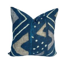 a blue and white pillow with an abstract design on the front, sitting on a white background