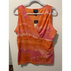 Add A Splash Of Color To Your Wardrobe With This Chaps Tie-Dye Top In Orange And Pink. The Sleeveless Top Features A V-Neckline And Is Perfect For Any Occasion, Whether It's A Casual Day Out Or A Business Meeting. The Lightweight Top Is Made Of Polyester And Is Machine Washable For Easy Care. This Women's Tunic Top Is Perfect For All Seasons And Has A Regular Fit In Size Xl. The Collarless Top Has A Fun And Colorful Tie-Dye Pattern That Will Make You Stand Out In A Crowd. Whether You're Attendin Summer Sleeveless Tie Dye Top, Sleeveless Tie Dye Summer Top, Summer Sleeveless Tie-dye Top, Women's Chaps, Orange And Pink, Women Tunic Tops, Business Meeting, Lightweight Tops, Tie Dye Patterns