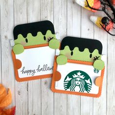 two starbucks coasters with happy halloween written on them