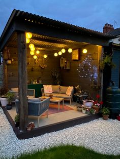 an outdoor living area is lit up at night with lights on the ceiling and furniture